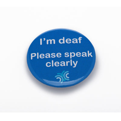 Blue pin badge featuring white lettered messaging 'I'm deaf - please speak clearly' pictured on white background