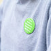 Person wearing green pin badge with white lettered message 'If you need to lipread me, please let me know'