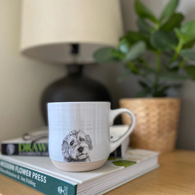 Stoneware mug with a detailed Cooper Cockapoo illustration, weighty feel and matt finish, designed and hand‑finished in the UK.