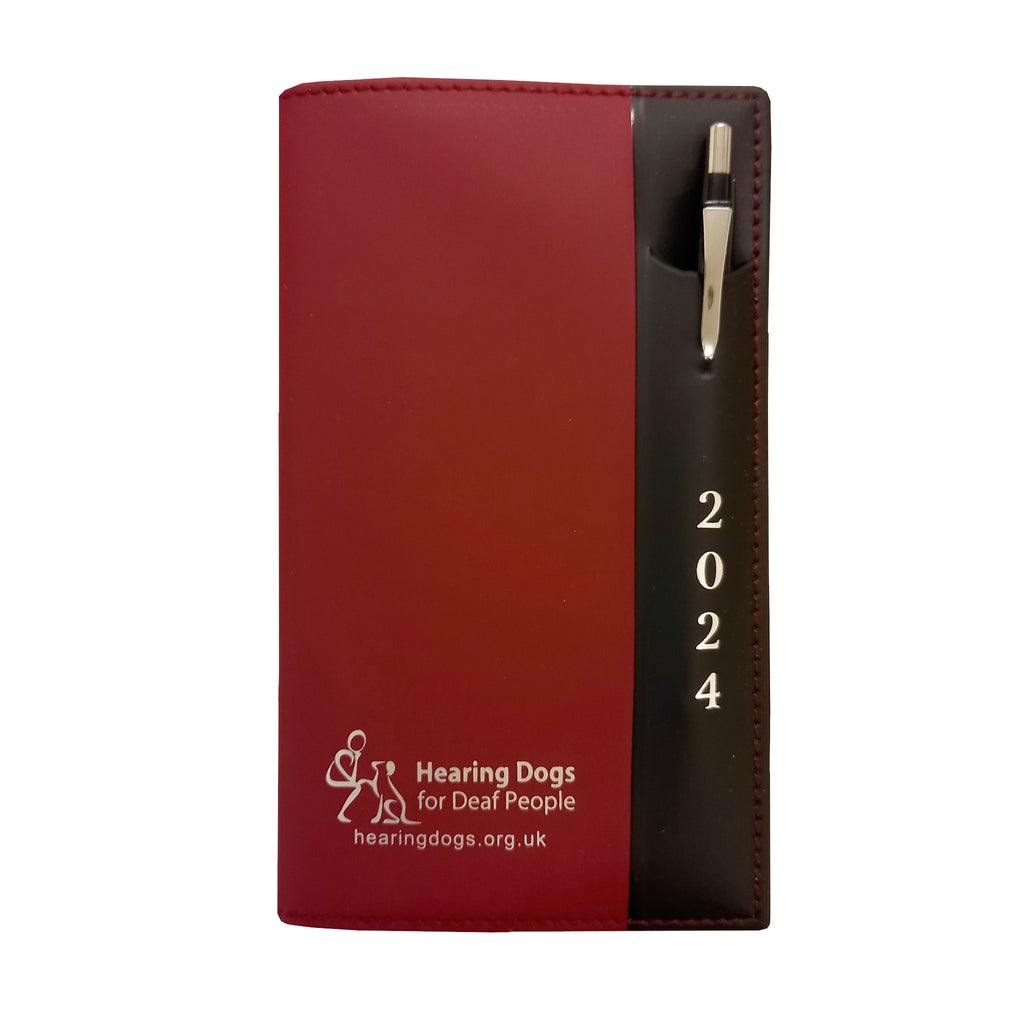 Matt burgundy diary with black panel down the right hand side. The Hearing Dogs logo and web address in at the bottom on the burgundy side. The black panel has a pouch which holds a silver effect pen and has the year 2024 underneath.