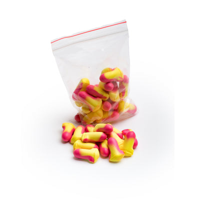 Pink and yellow soft foam earplugs displayed in clear transparent bag and loose on a white background.