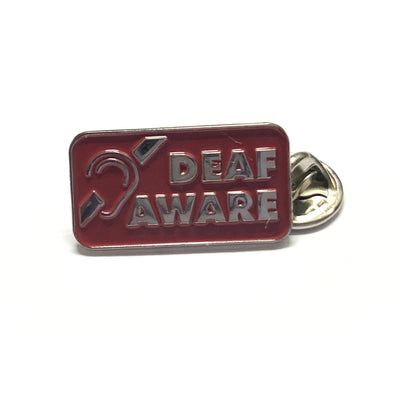 Red enamel pin badge with silver embellishments featuring the message DEAF aware and international deaf symbol