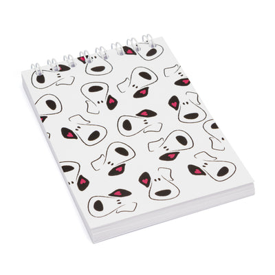 A rectangular wire-bound notepad with multiple cartoon puppy faces on the cover.