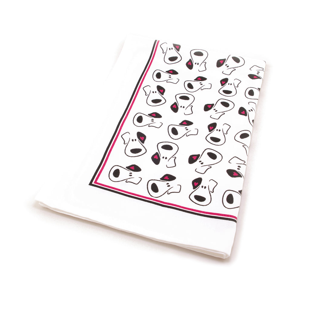 Folded cotton tea towel with a cartoon puppy face repeat design all over it. Tea towel has plain border with a thin black and a thin red line surround the puppy faces.