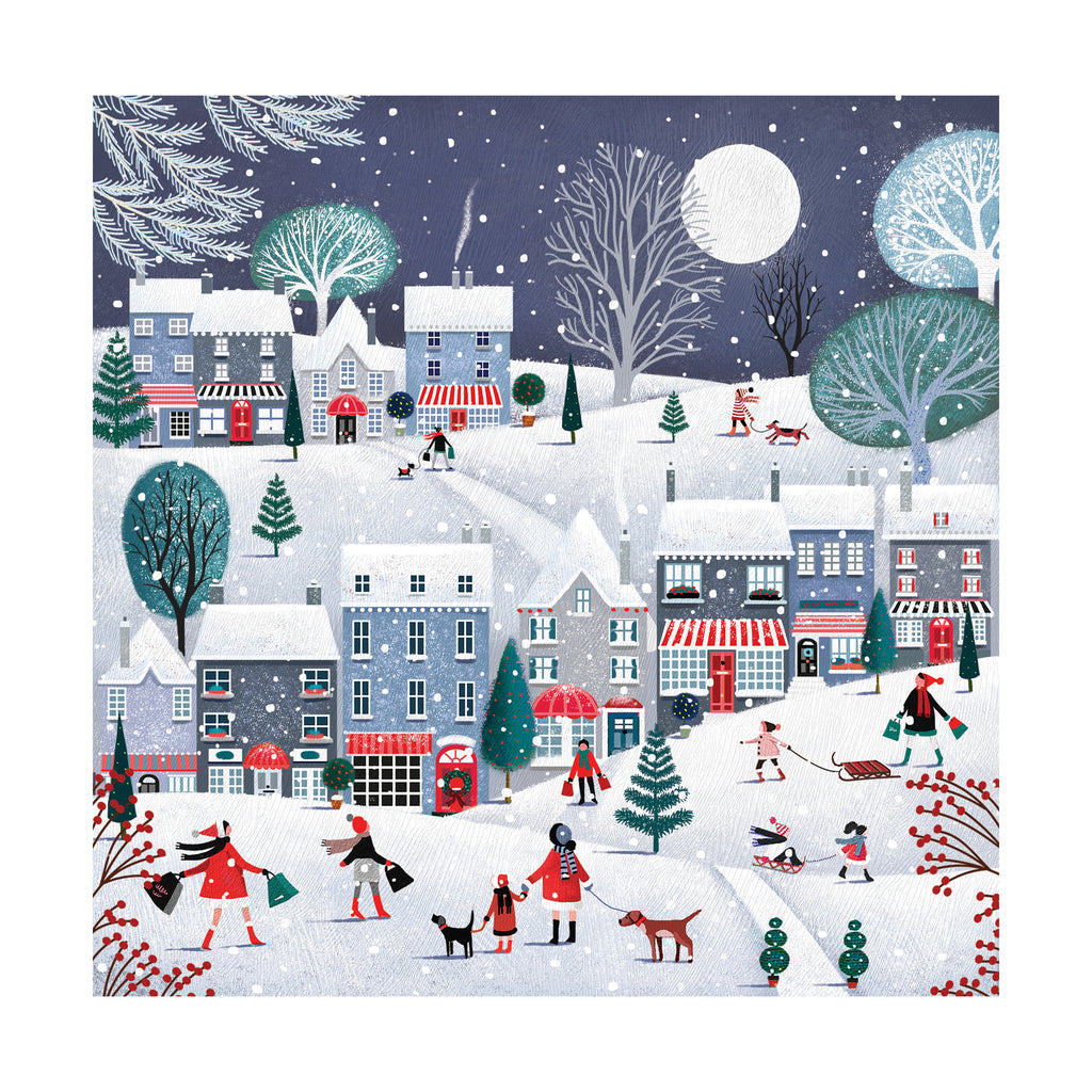 The image on the front of the card is of a beautifully illustrated Christmas snowy village, featuring two rows of 3 and 4 storey houses, and different types of trees, all covered in snow. There are illustrated people in front of the houses doing a mixture of the following activities: going for a walk with dogs in snow, carrying shopping bags; going for a sleigh ride. The sky is a dark grey colour with a big white circular moon in. Little white circles scattered across the image to create a snow fall effect.
